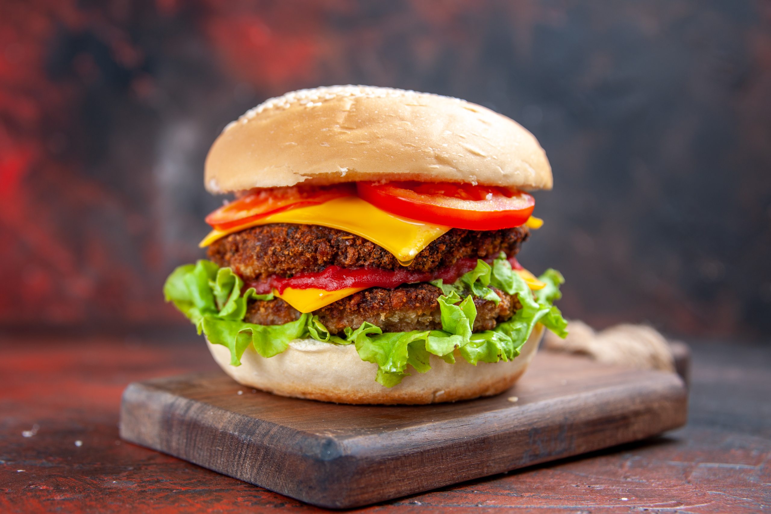 front-view-meat-burger-with-cheese-salad-tomatoes-dark-floor